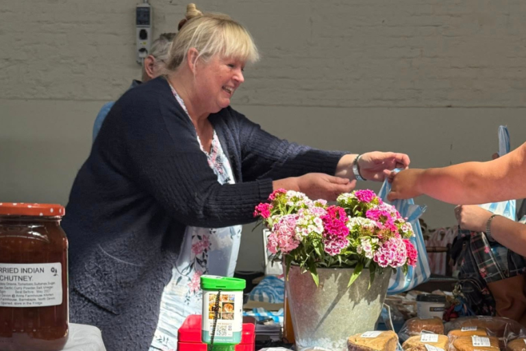 Ann from Farmhouse Bakes handing a customer their order