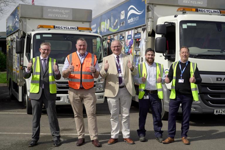 Council staff with thumbs up infront of recycling vehicles