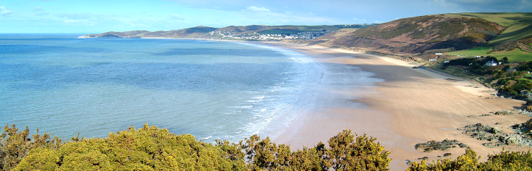 A landscape image of Woolacombe Beach, in North Devon